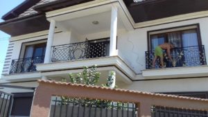 balustrade-balcon-fier-forjat-decor-auriu Balustrade din fier forjat la balcon, cu decor auriu, montate pe o casă cu etaj