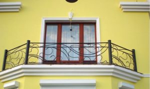 balcon-modern-cu-balustrada-din-fier-forjat-curbat Balcon cu balustradă din fier forjat ondulat pe fațadă galbenă