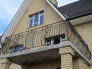 balcon-fier-forjat-model-decorativ-casa-caramida Balcon din fier forjat decorativ montat pe casă din cărămidă galbenă