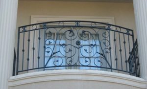 balcon-fier-forjat-rotund-cu-volute-si-flori Balcon din fier forjat cu model floral și volute elegante, montat pe balustradă rotundă