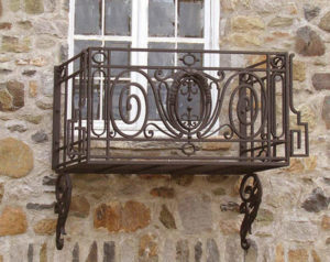 balcon-fier-forjat-decorativ-pe-fatada-din-piatra Balcon din fier forjat montat pe fațadă de piatră cu volute decorative