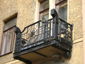 balcon-fier-forjat-flori-razesolare-art-deco-cladire-veche Balcon din fier forjat cu motive florale și panou central în formă de raze